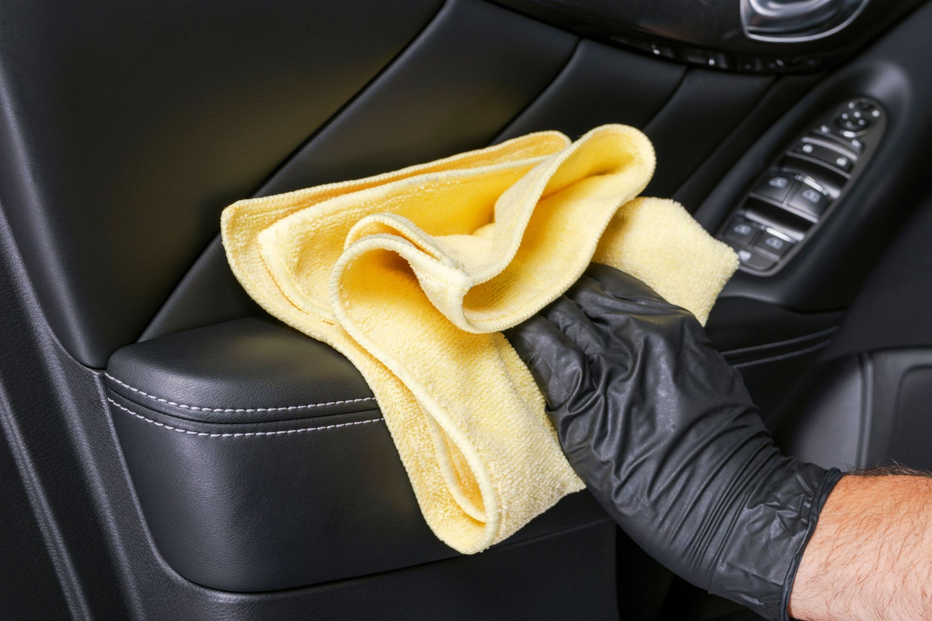 A man cleaning car door handle cloth. Car detailing. Valeting concept. Selective focus. Car detailing. Cleaning with sponge. Worker cleaning. Cleaning solution concept